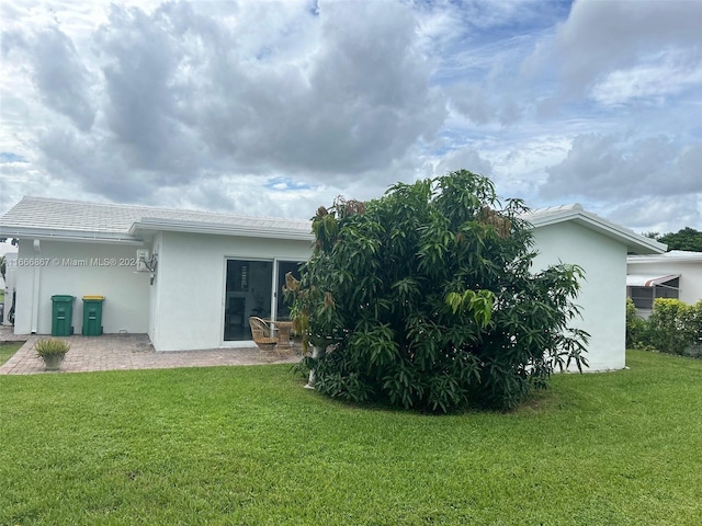 back of property with a yard and a patio area