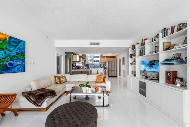 living room with a textured ceiling and light tile patterned floors