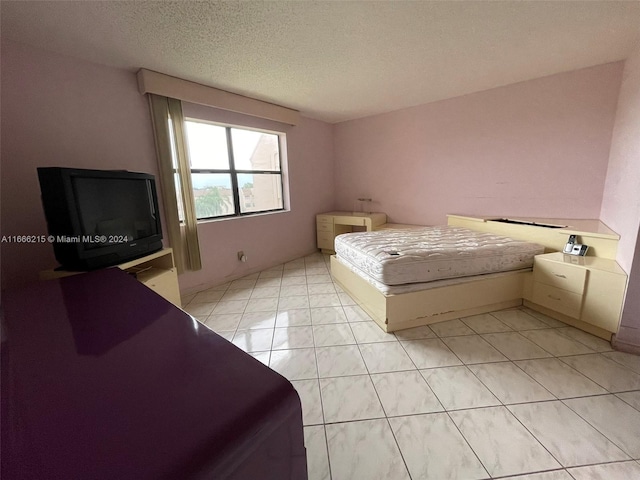 unfurnished bedroom featuring a textured ceiling and light tile patterned floors