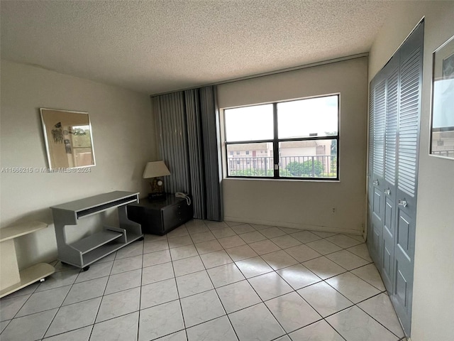 sitting room with a textured ceiling and light tile patterned floors