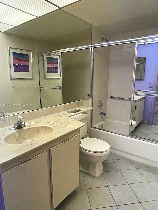 full bathroom with enclosed tub / shower combo, vanity, toilet, and tile patterned floors