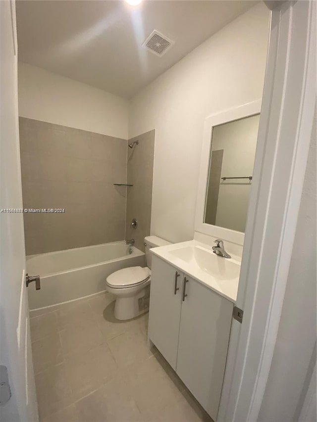 full bathroom featuring tiled shower / bath combo, vanity, toilet, and tile patterned floors