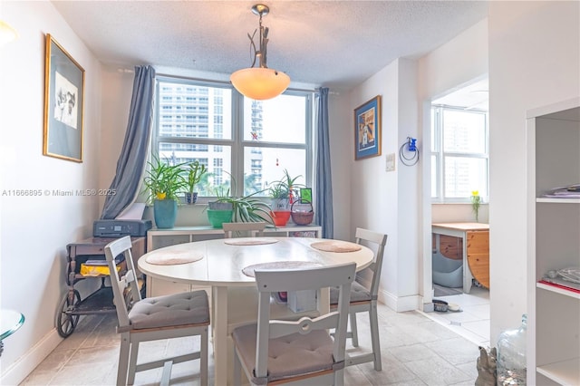 1849 S Ocean Dr Unit 415, Hallandale Beach, FL 33009 - dining area with plenty of natural light, baseboards, and a textured ceiling