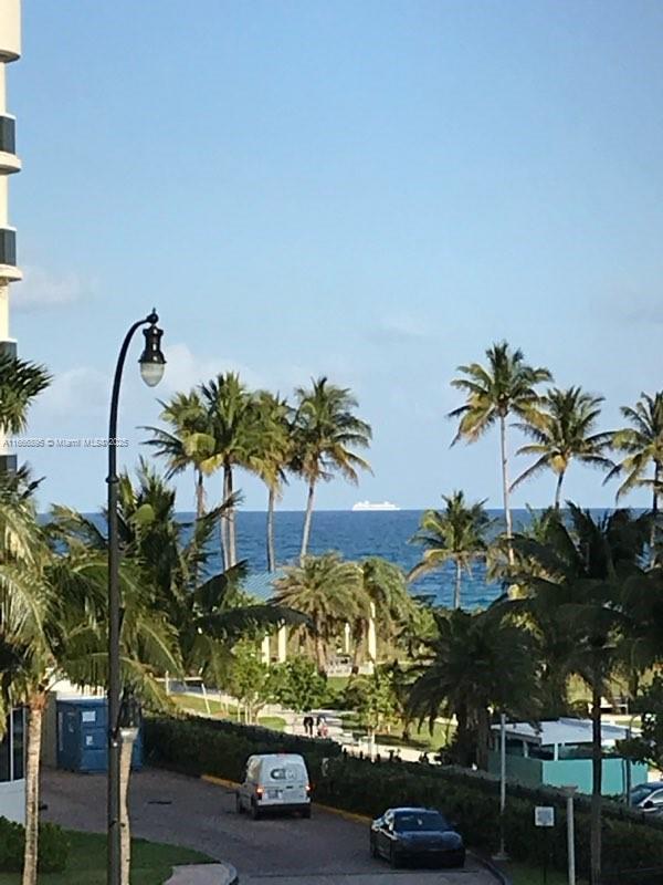 birds eye view of property with a water view and a beach view