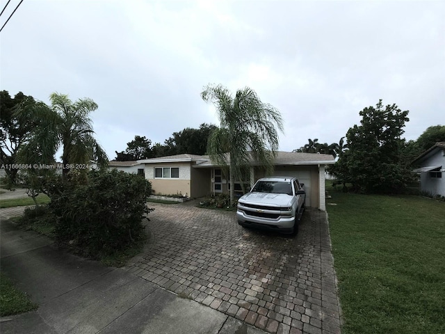 single story home featuring a front lawn and a garage