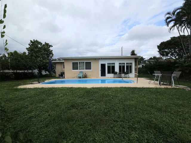 back of property with a lawn and a patio