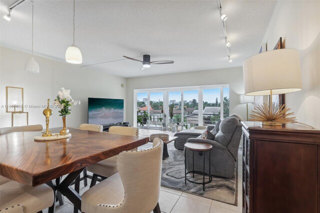 tiled dining area featuring ceiling fan, track lighting, and a textured ceiling