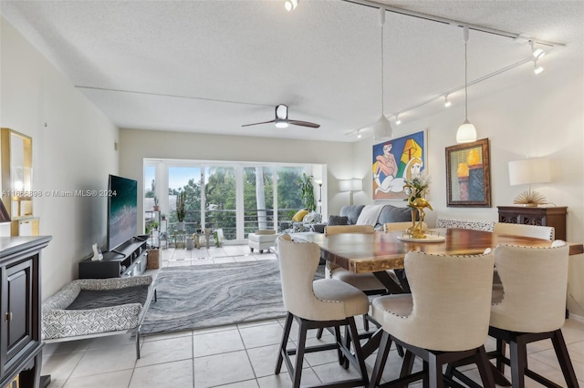 dining area with light tile patterned floors, rail lighting, and a textured ceiling