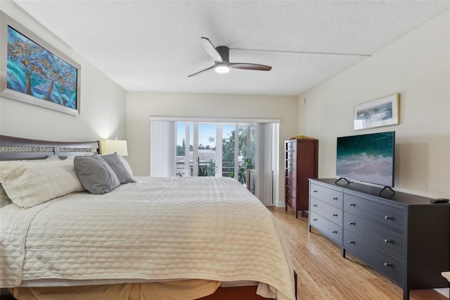 bedroom featuring ceiling fan, access to exterior, light hardwood / wood-style floors, and a textured ceiling