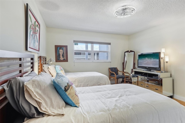 bedroom with hardwood / wood-style flooring and a textured ceiling