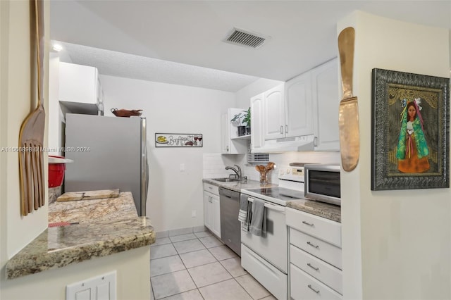 kitchen featuring light tile patterned floors, sink, appliances with stainless steel finishes, light stone counters, and white cabinets