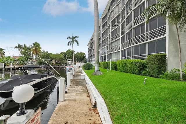 exterior space with a yard, a dock, and a water view