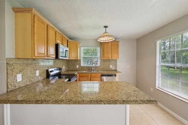 kitchen featuring appliances with stainless steel finishes, backsplash, kitchen peninsula, pendant lighting, and sink