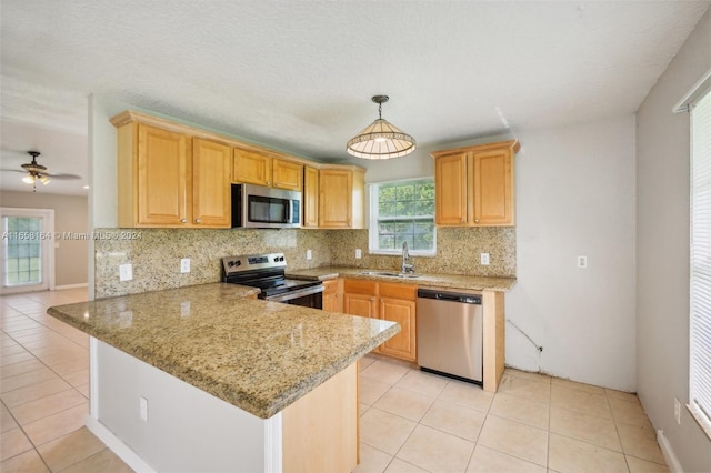 kitchen featuring light stone counters, tasteful backsplash, kitchen peninsula, stainless steel appliances, and ceiling fan