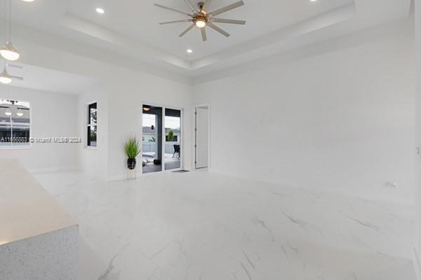 spare room featuring a raised ceiling and ceiling fan