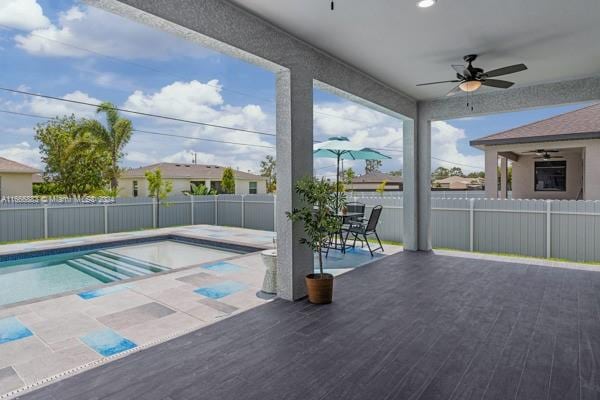 view of swimming pool with a deck, a hot tub, ceiling fan, and a patio area