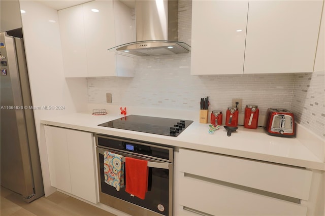 12750 SW 15th St Unit 106D, Pembroke Pines, FL 33027 - kitchen with wall chimney exhaust hood, stainless steel appliances, white cabinetry, and light countertops