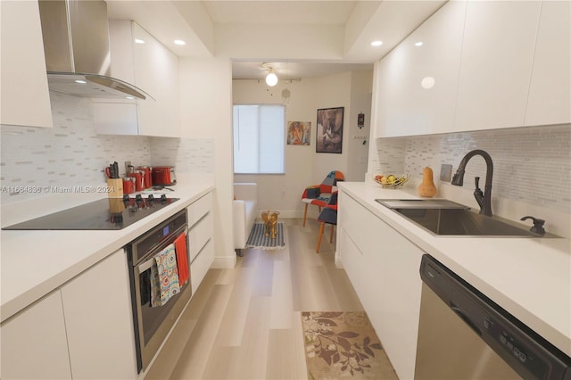 12750 SW 15th St Unit 106D, Pembroke Pines, FL 33027 - kitchen featuring wall chimney range hood, stainless steel appliances, modern cabinets, white cabinets, and light countertops