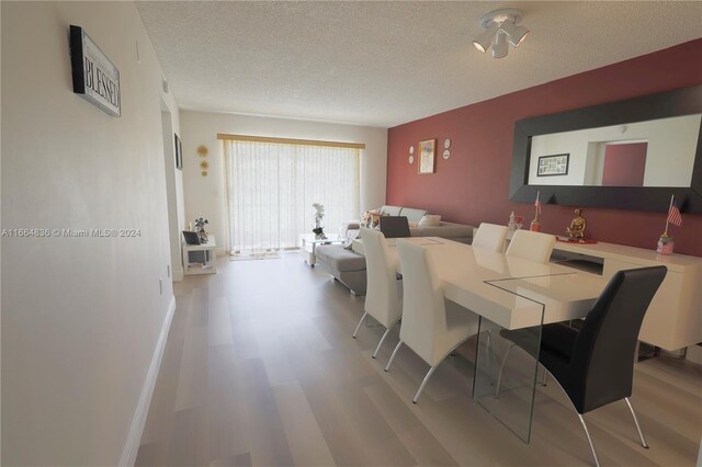 12750 SW 15th St Unit 106D, Pembroke Pines, FL 33027 - dining area with a textured ceiling and wood finished floors