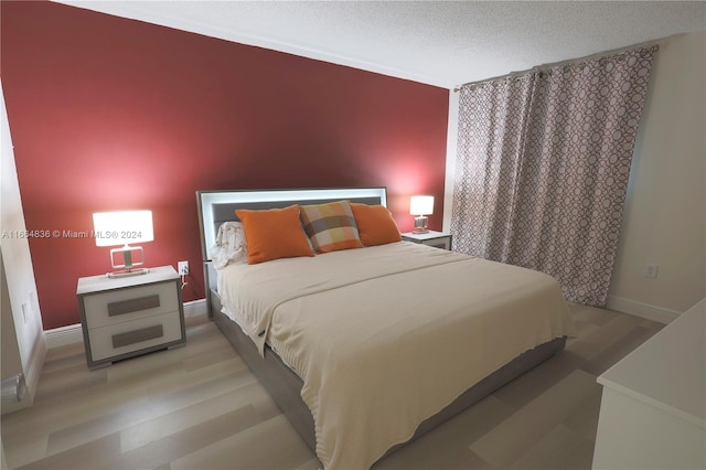 bedroom featuring a textured ceiling and light hardwood / wood-style floors