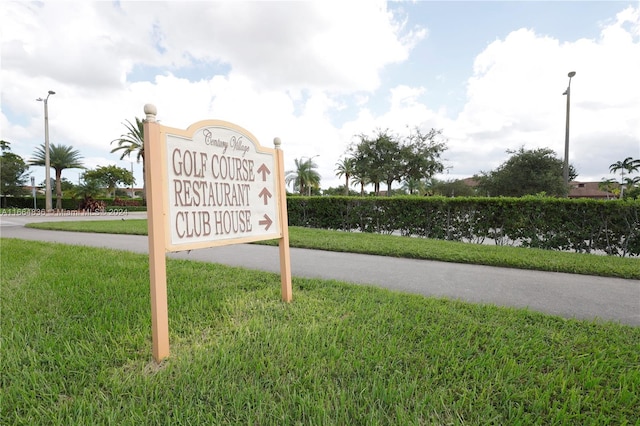 community sign with a yard and a water view