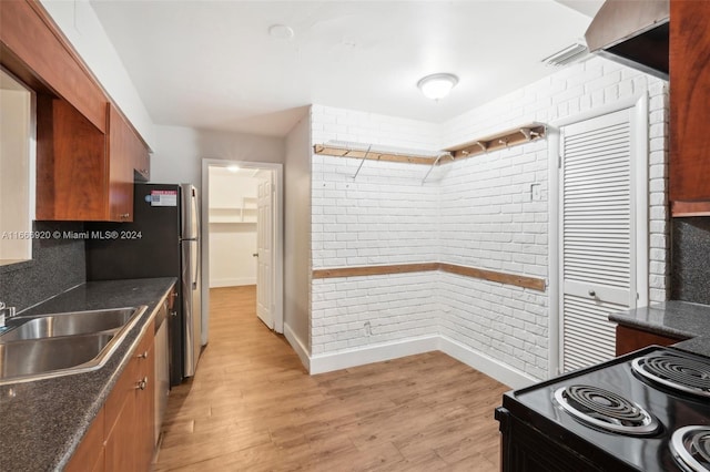 kitchen featuring stainless steel range oven, sink, and light hardwood / wood-style flooring