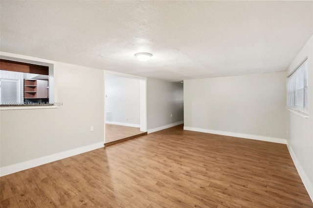 basement with a textured ceiling and hardwood / wood-style floors