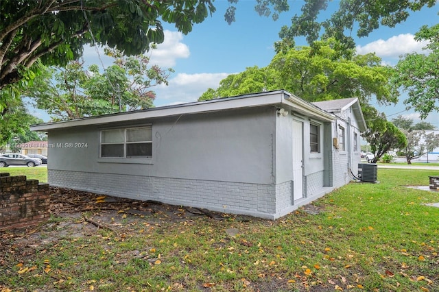 view of property exterior featuring a lawn and cooling unit