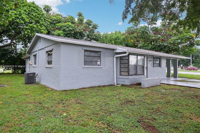 single story home featuring central AC unit and a front lawn