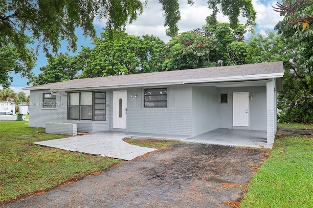 ranch-style house with a front lawn and a carport