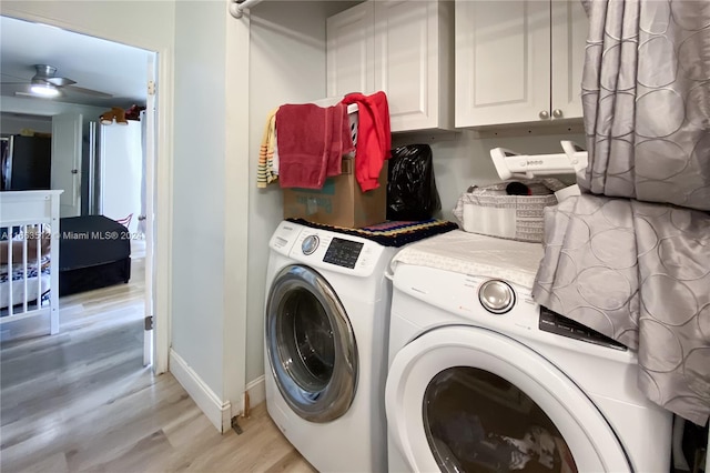 laundry room with washing machine and dryer, light hardwood / wood-style floors, ceiling fan, and cabinets