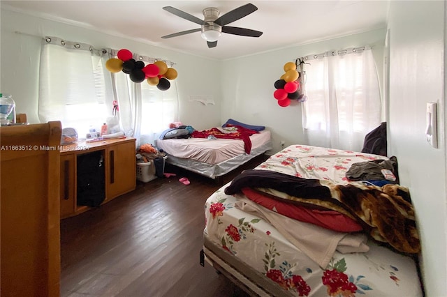 bedroom featuring ornamental molding, multiple windows, ceiling fan, and dark hardwood / wood-style flooring