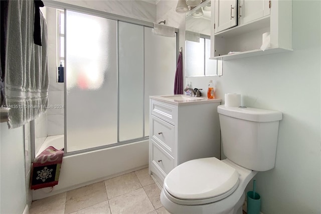 full bathroom featuring combined bath / shower with glass door, vanity, toilet, and tile patterned flooring