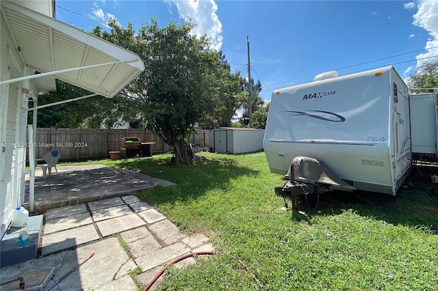 view of yard with a storage shed and a patio area