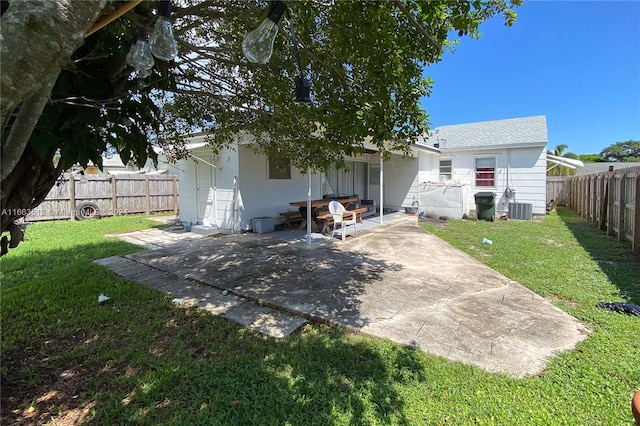 back of property with cooling unit, a yard, and a patio area