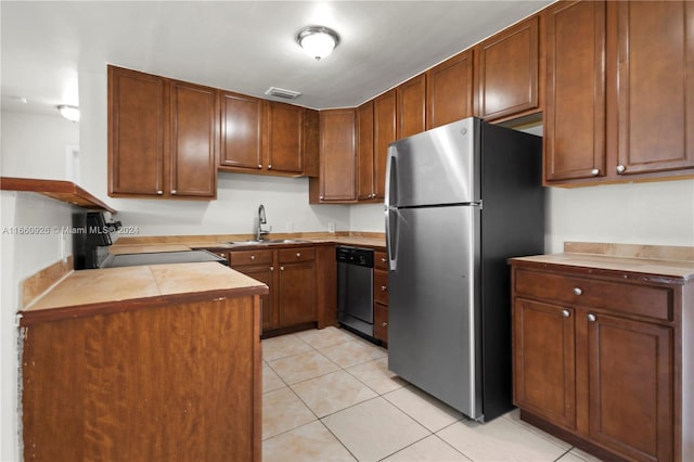 kitchen with appliances with stainless steel finishes, sink, and light tile patterned floors