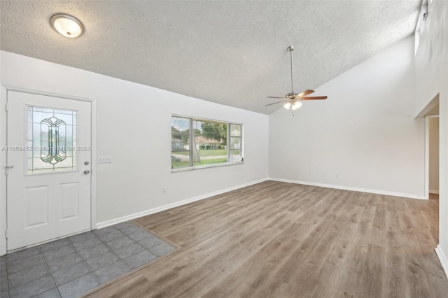 entryway with high vaulted ceiling, ceiling fan, hardwood / wood-style flooring, and a textured ceiling