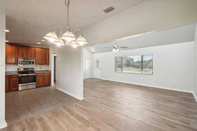 kitchen with pendant lighting, wood-type flooring, a textured ceiling, ceiling fan with notable chandelier, and appliances with stainless steel finishes