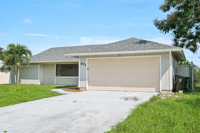 ranch-style home with a garage and a front lawn