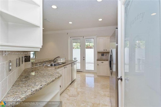 kitchen featuring light stone counters, white cabinets, sink, french doors, and appliances with stainless steel finishes