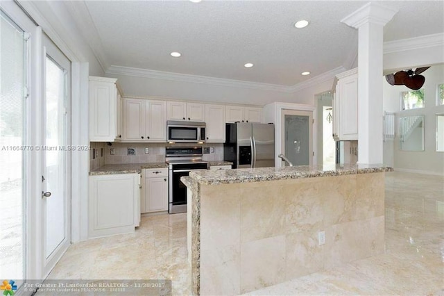 kitchen featuring appliances with stainless steel finishes, ornamental molding, light stone countertops, and white cabinets