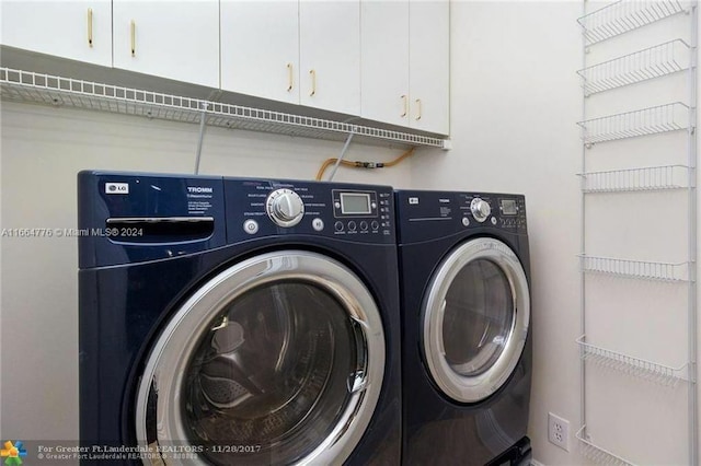 laundry area featuring washing machine and clothes dryer and cabinets