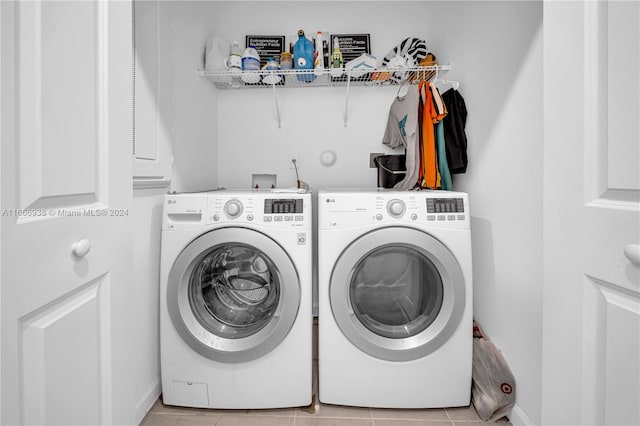 washroom with light tile patterned floors and washing machine and dryer