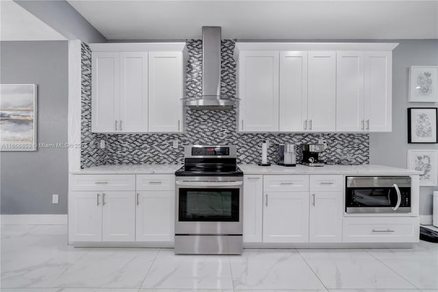 kitchen with wall chimney range hood, appliances with stainless steel finishes, and white cabinetry