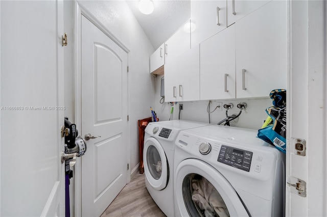 laundry room with cabinet space, light wood finished floors, and separate washer and dryer