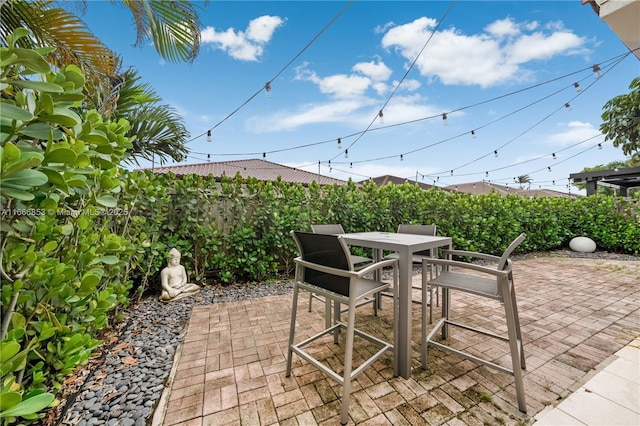 view of patio with outdoor dining area and fence