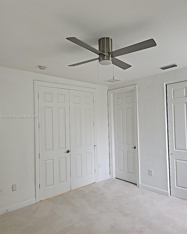 unfurnished bedroom featuring ceiling fan and light colored carpet