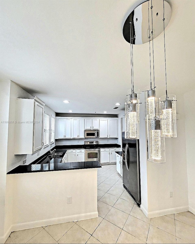 kitchen featuring pendant lighting, light tile patterned flooring, white cabinetry, kitchen peninsula, and stainless steel appliances