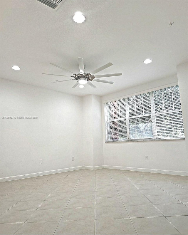 empty room featuring ceiling fan and light tile patterned flooring