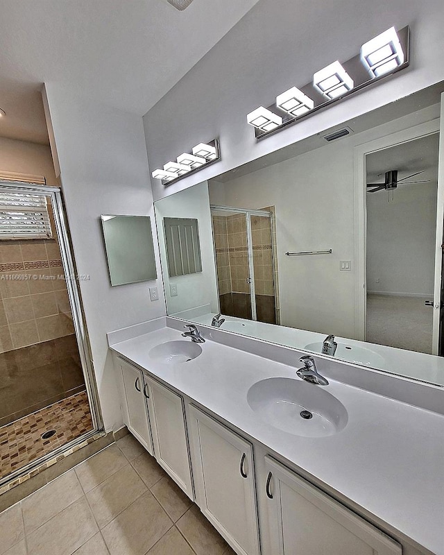 bathroom featuring vanity, a shower with shower door, and tile patterned flooring